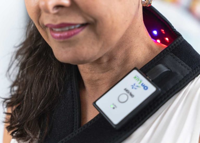 Person wearing OnLux Shoulder Pad, with remote attached.