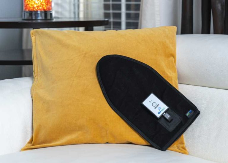 OnLux Hand & Wrist Mitt resting on yellow pillow.